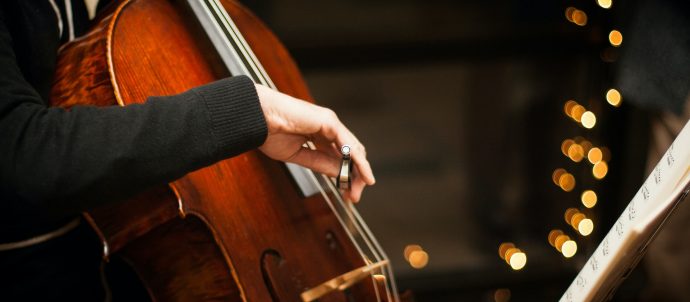 A closeup of an arm playing the cello