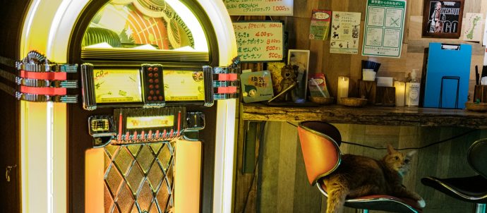 A jukebox with a cat on a chair