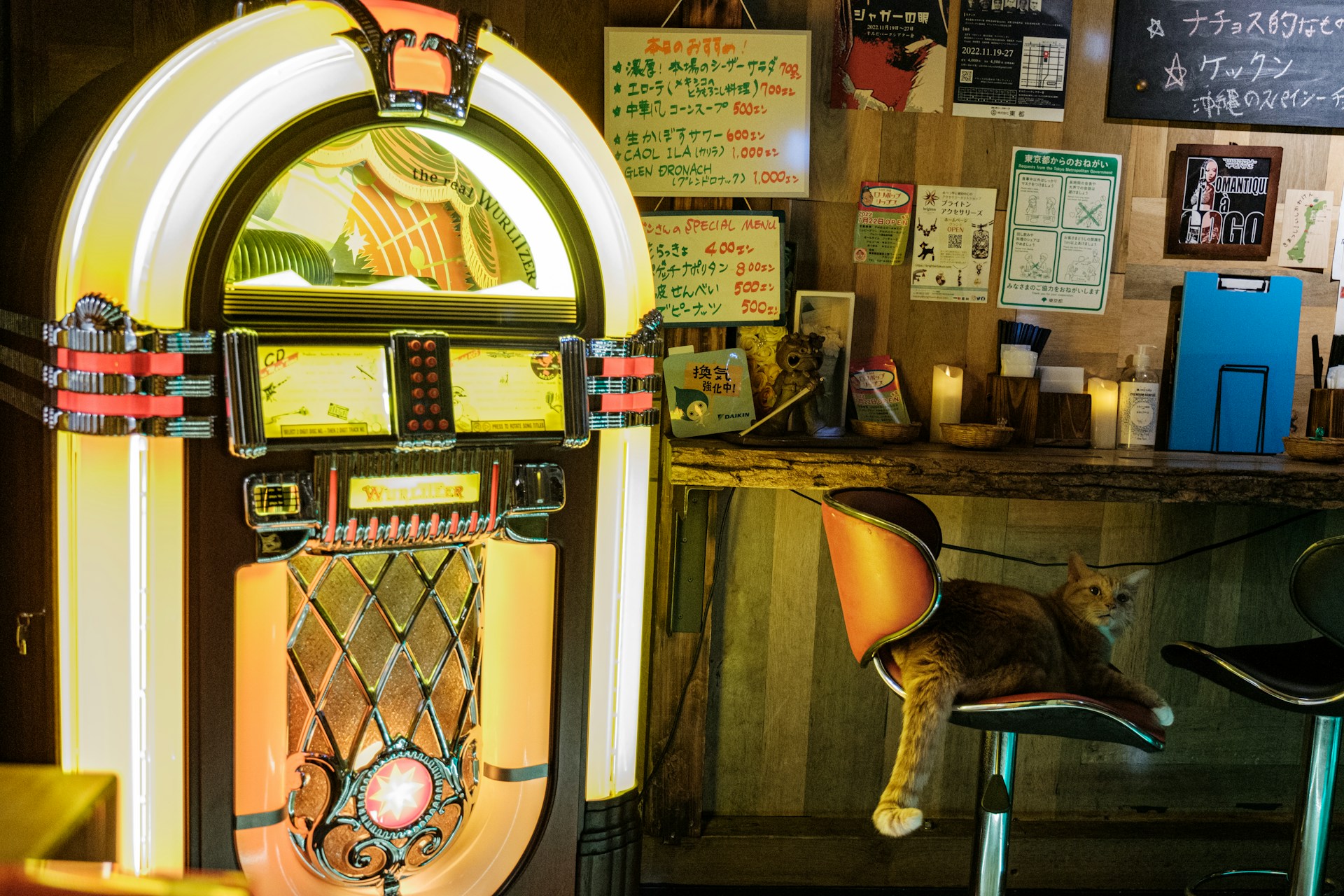 A jukebox with a cat on a chair