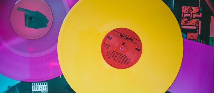 A bright yellow vinyl record on top of purple records
