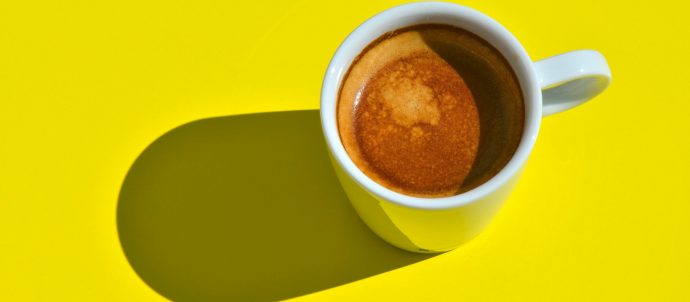 Cup of coffee on yellow background