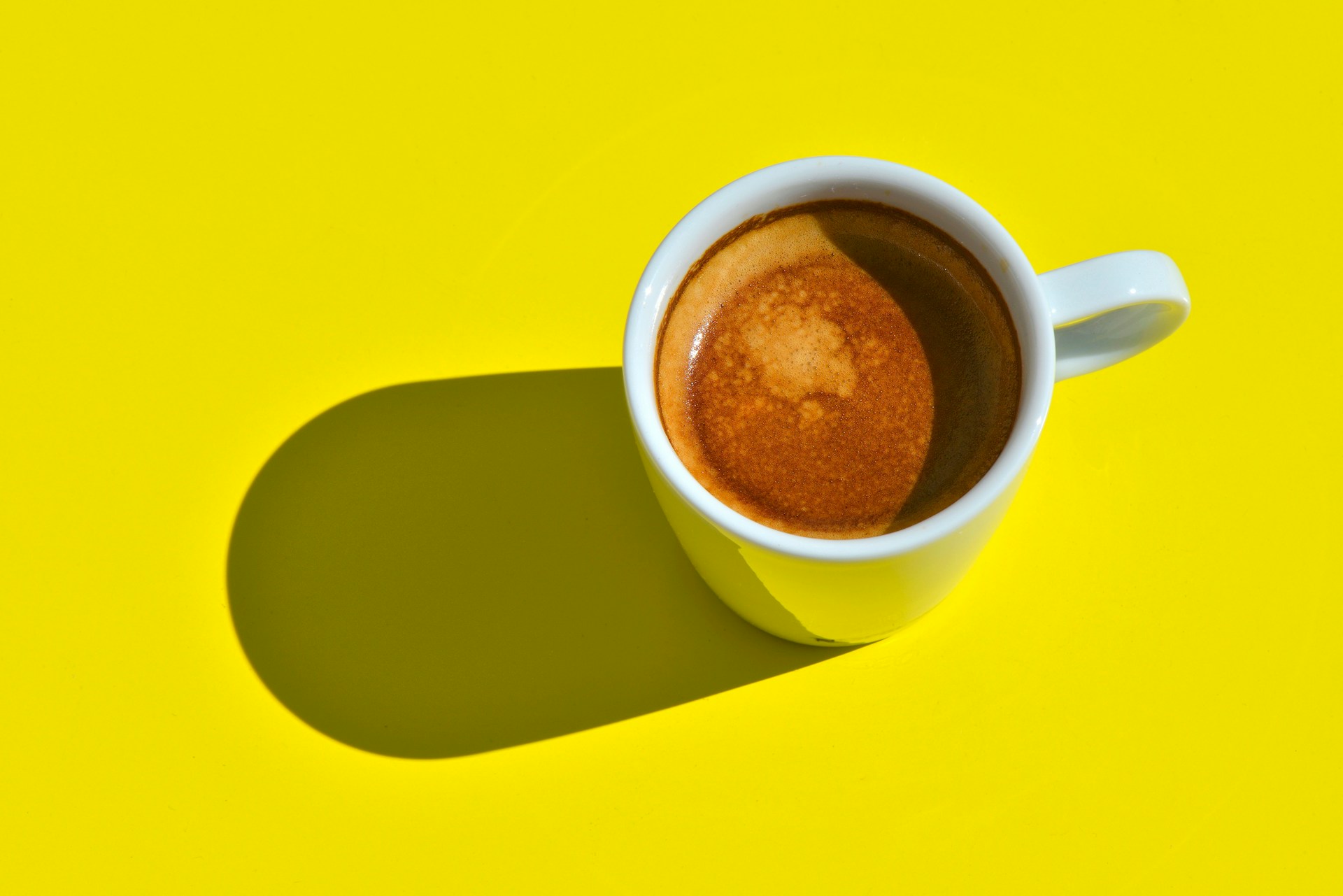 Cup of coffee on yellow background